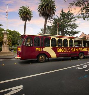 a red and yellow bus driving down a street