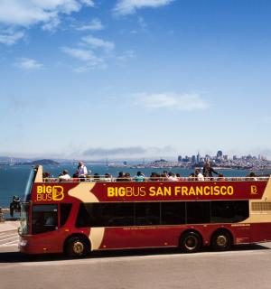a red double decker bus driving down a street