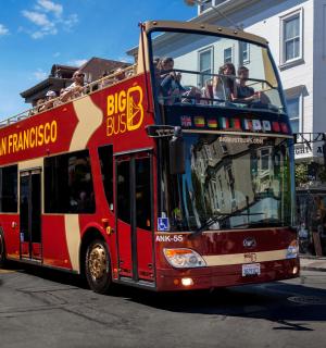 a red double decker bus driving down a street