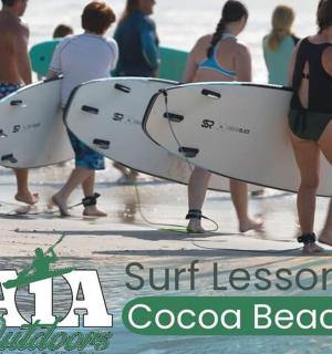 一群人带着冲浪板在海滩上散步