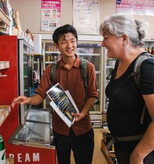 一名女子站在商店里与一名男子交谈