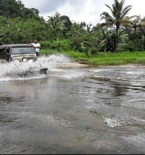 a jeep driving through a river in the water