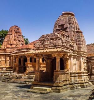 田野中的一座大型石头建筑，背景是群山
