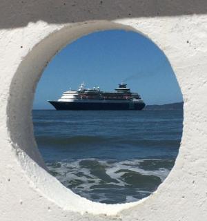 a cruise ship in the ocean through a hole in a wall