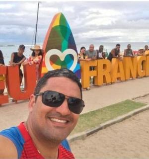 一名戴着墨镜的男子站在冲浪板前