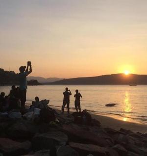 一群人站在海滩上看日落