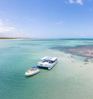 two boats in the water next to a beach