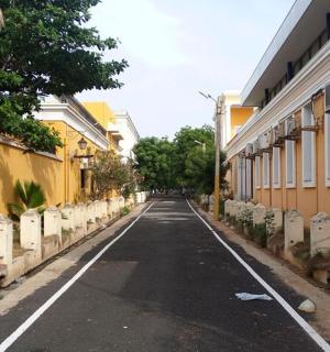 an empty street in a town with yellow buildings