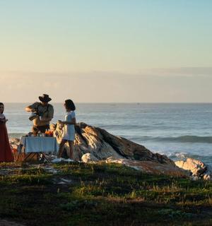 一群人坐在海边的岩石上