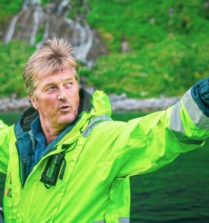 a man in a yellow jacket standing in the water