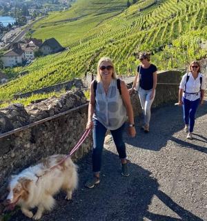 two women walking a dog on a path