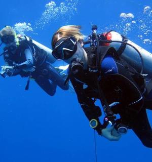 ıslak kıyafetli bir kişi okyanusta yüzüyor