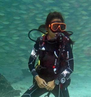 suda dalgıç kıyafeti ve gözlük takan bir kadın