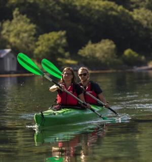 two people are in a kayak on a lake