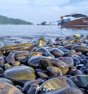 a group of rocks on the water with a boat