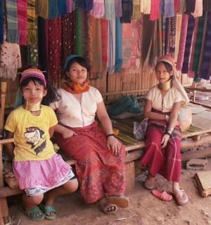 三个年轻女孩坐在商店的长椅上