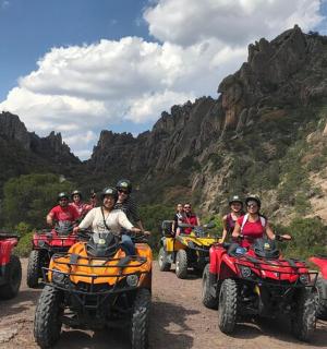 一群人骑着四轮摩托车在土路上行驶