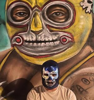 a man wearing a mask in front of a painting