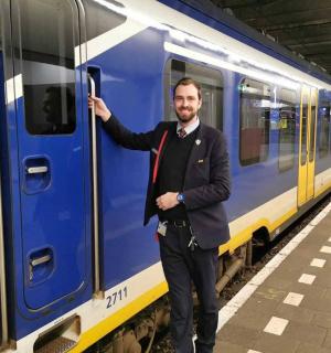 a man is standing next to a blue train