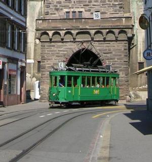 a green trolly car driving through a tunnel