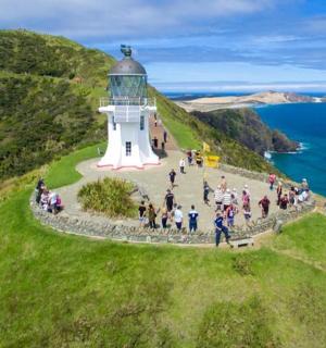 一群人在山上的灯塔周围散步
