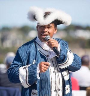 a man wearing a hat speaking into a microphone