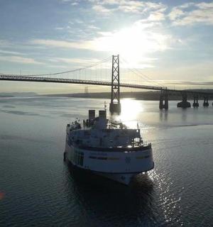 a boat in the water in front of a bridge
