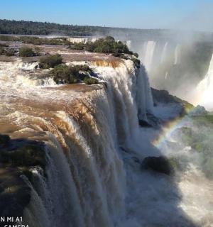 an aerial view of a waterfall with a rainbow