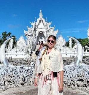 一位女士在白色寺庙前拍照