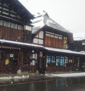 a snow covered street with a building in front