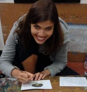 一位女士坐在桌边，手里拿着一张纸