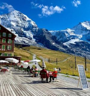 skupina lidí sedících u stolu před horou