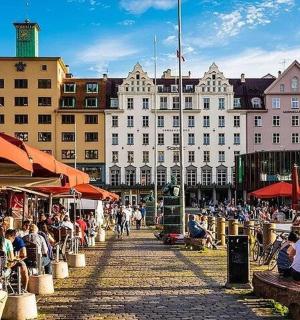 一群人坐在建筑物前的桌子旁