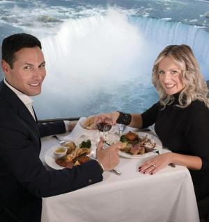 a man and woman sitting at a table with a plate of food