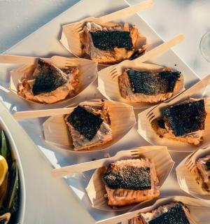 a white table with plates of food on chop sticks