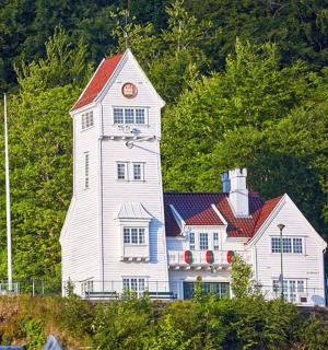 a large white house with a clock tower on a hill