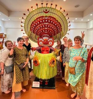 a group of women standing in front of a statue
