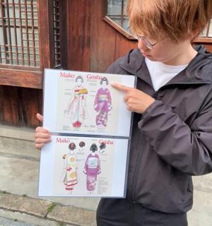 a girl is holding a poster with a drawing on it