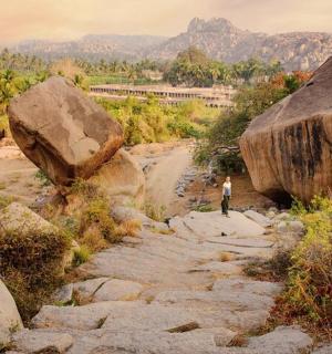 一名男子沿着布满大石头的岩石小路行走