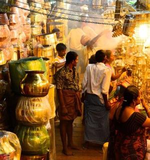 a group of people standing around a store with vases