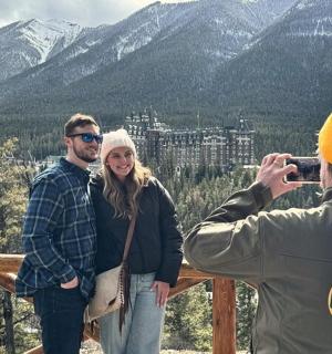 ein Mann, der ein Foto von einer Frau in den Bergen macht