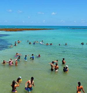 a group of people in the water at the beach