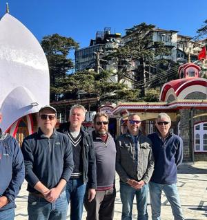 en gruppe mænd står foran en bygning