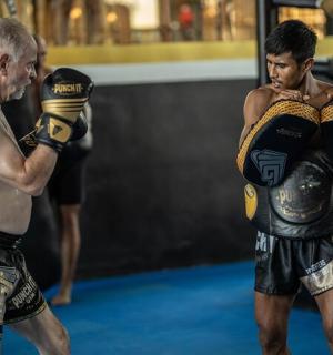 two men standing in a ring with boxing gloves