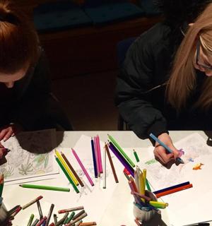 两位女士在桌子上用彩色铅笔工作