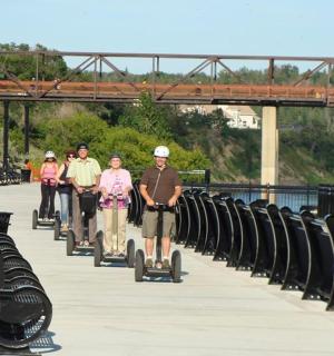 a group of people walking on a bridge with segways