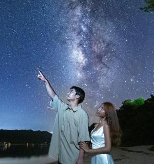 a man and a woman looking up at the night sky