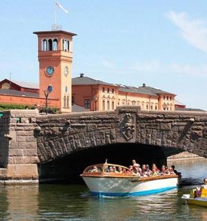 eine Gruppe von Menschen auf einem Boot unter einer Brücke