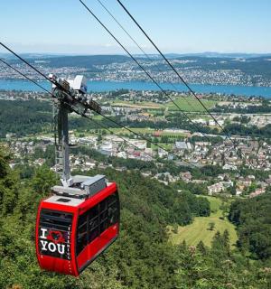 Červená lanovka letící nad městem