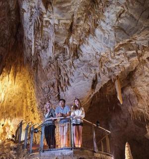 skupina lidí stojících na zábradlí v jeskyni